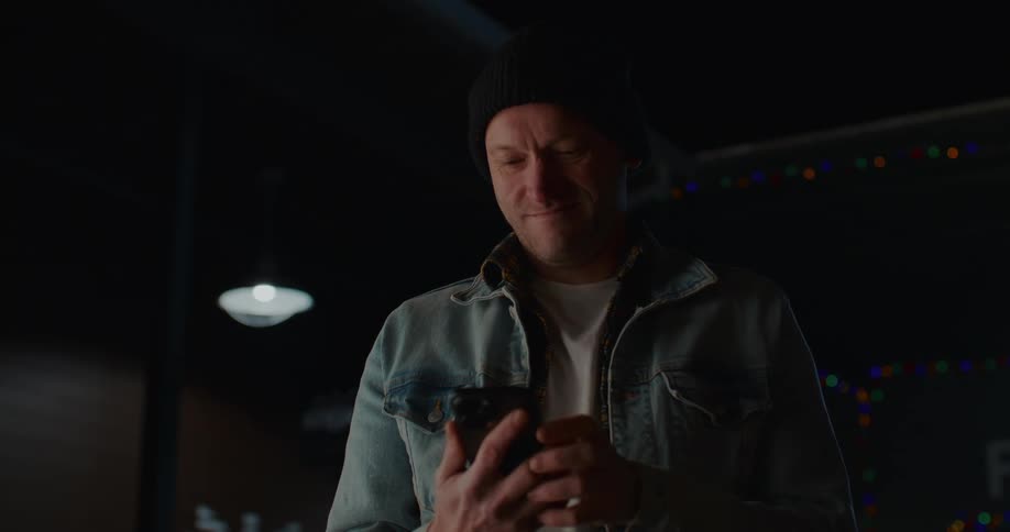 A man smiles while using his cell phone