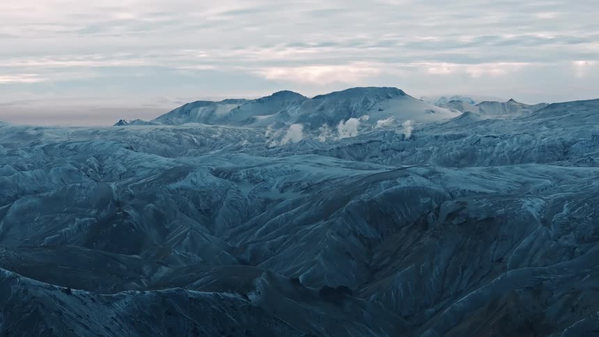 Aerial view of steam or smoke columns rising from a mounainous landscape