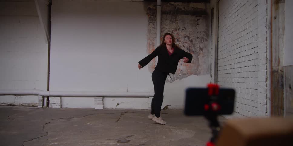 A woman films herself dancing