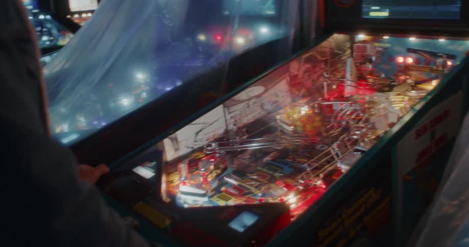 A man is playing the pinball machine