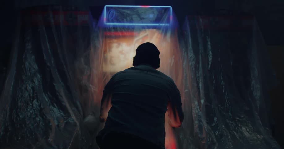 A man takes the plastic sheet off a pinball machine