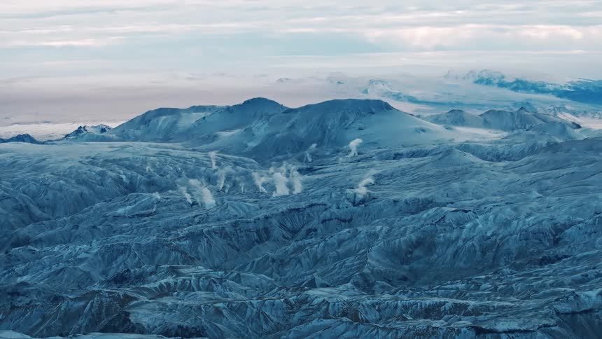 A panoramic view of a rocky terrain with deep crevices and misty mountains