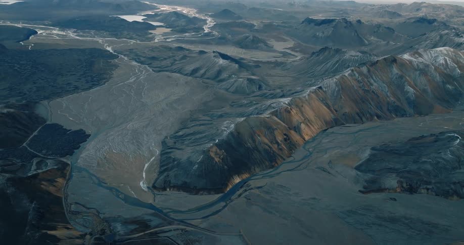 Aerials of mountains and canyons grey sky can be seen in the distance