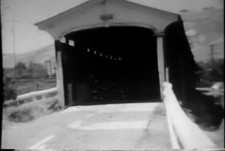 A covered bridge that is dark inside