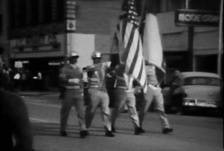 Four men march down the street