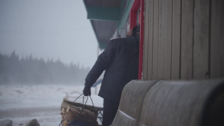 A man bundled up against the cold walks through a doorway