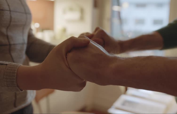 Closet in the hands of two people clasping their hands