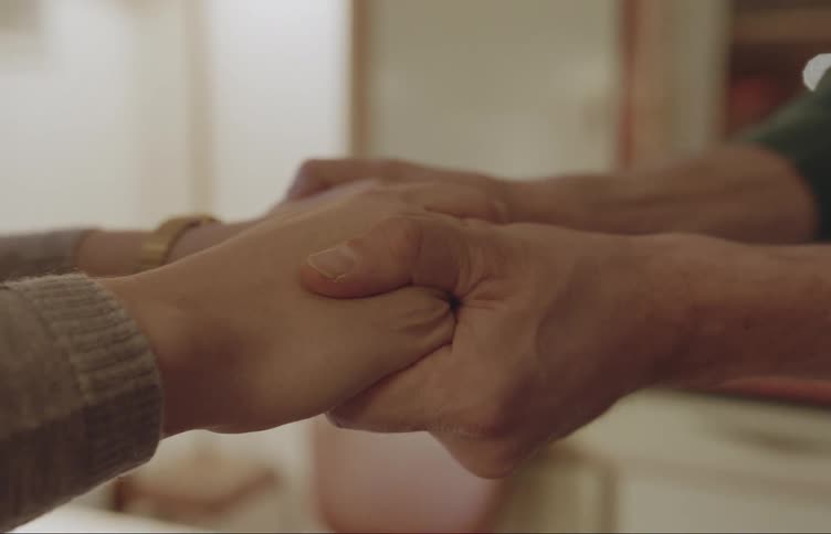 Closeup of two people clasping hands and then letting go of each other