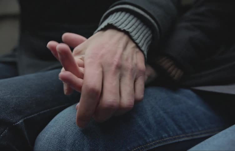 Two people sitting holding hands
