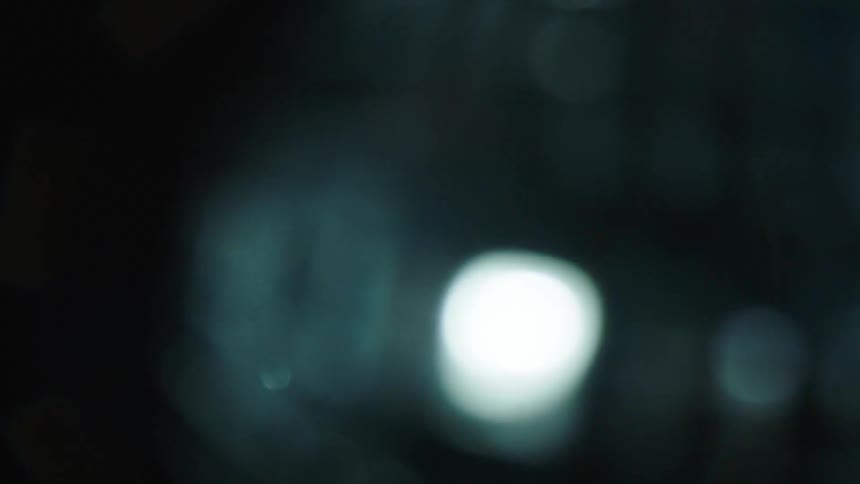 A blurred object spins as its surface reflects back a bright light