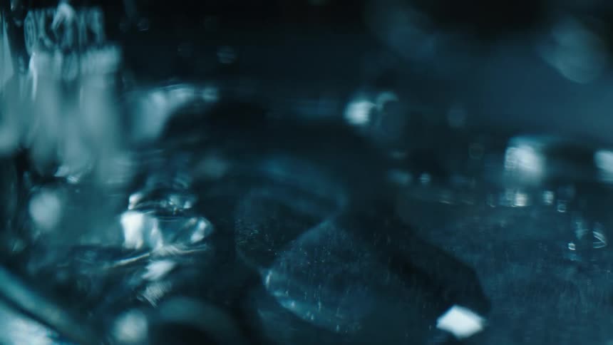 Close up of water droplets falling over a blue hard surface