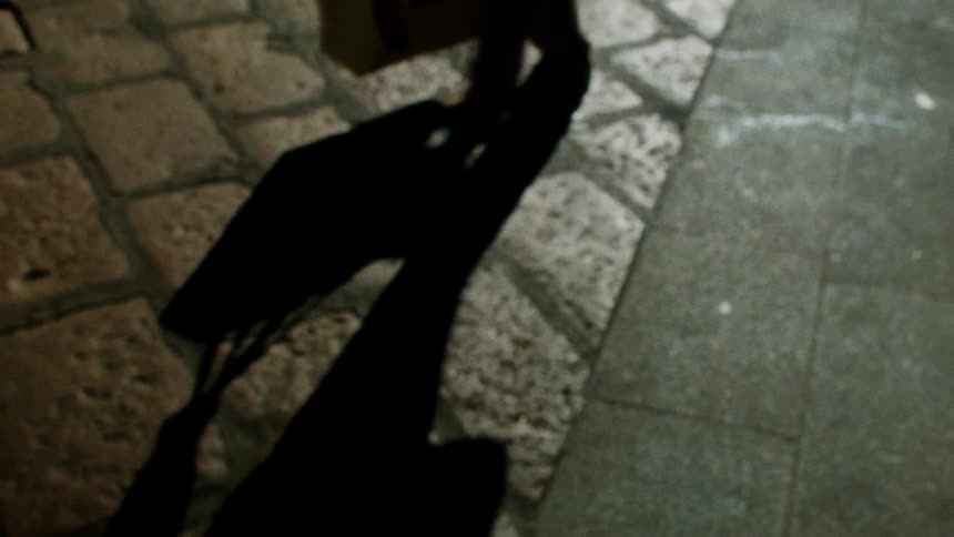 A person walks by on the cobblestone
