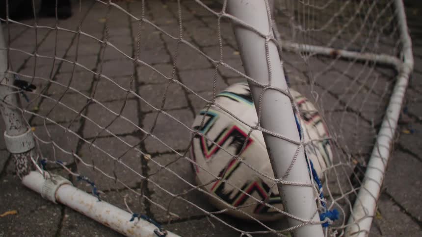 A soccer ball entering the goal net