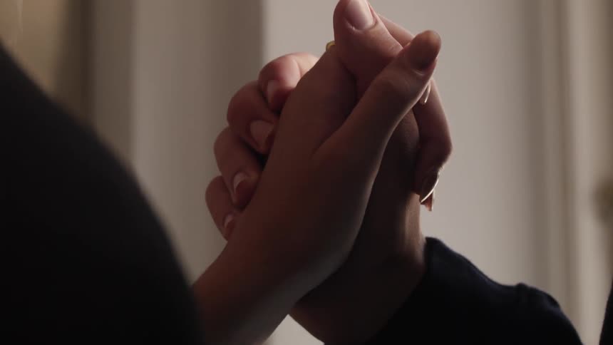 Closeup of the hands of two people holding hands