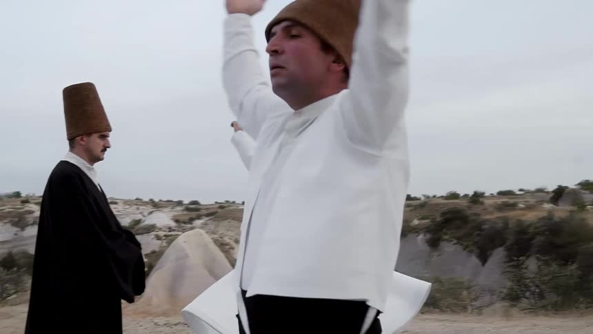 Whirling dervishes spin in traditional clothes hands lifted high in the Cappadocia Turkey