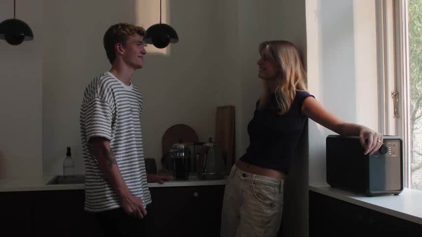 Man and woman standing in kitchen talking smiling