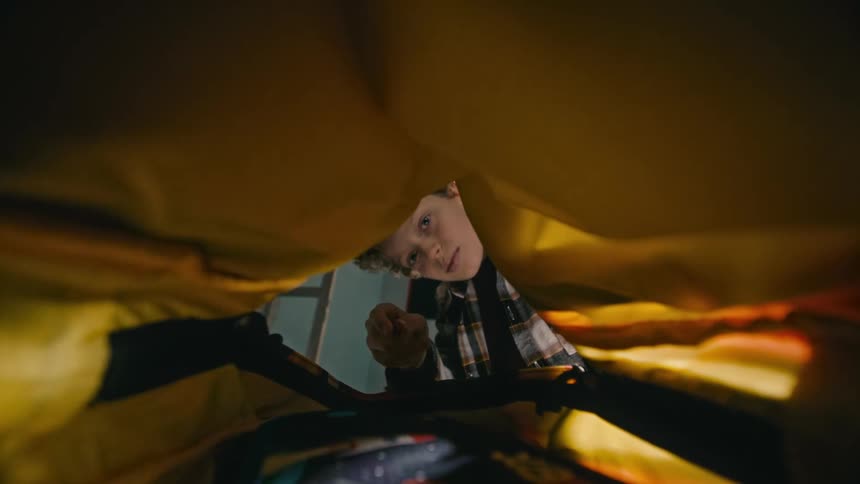 A young male opens a book back a places school supplies inside of it