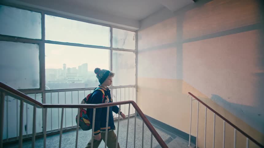 A young boy descends a staircase