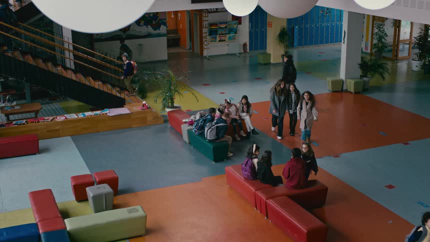 A crowd of kids walk through a school lobby