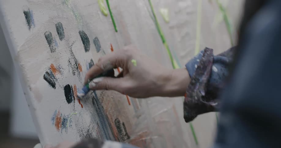 Someone painting with crayons on canvas