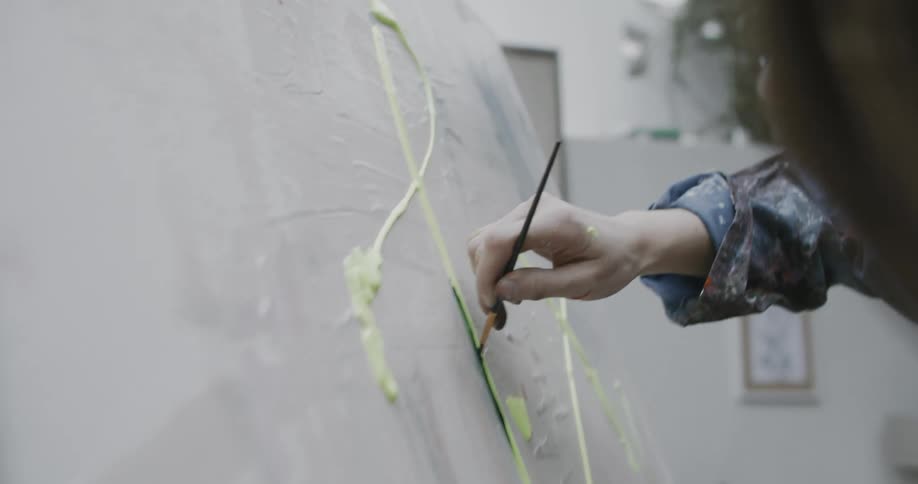 A white woman creates a painting on a white canvas