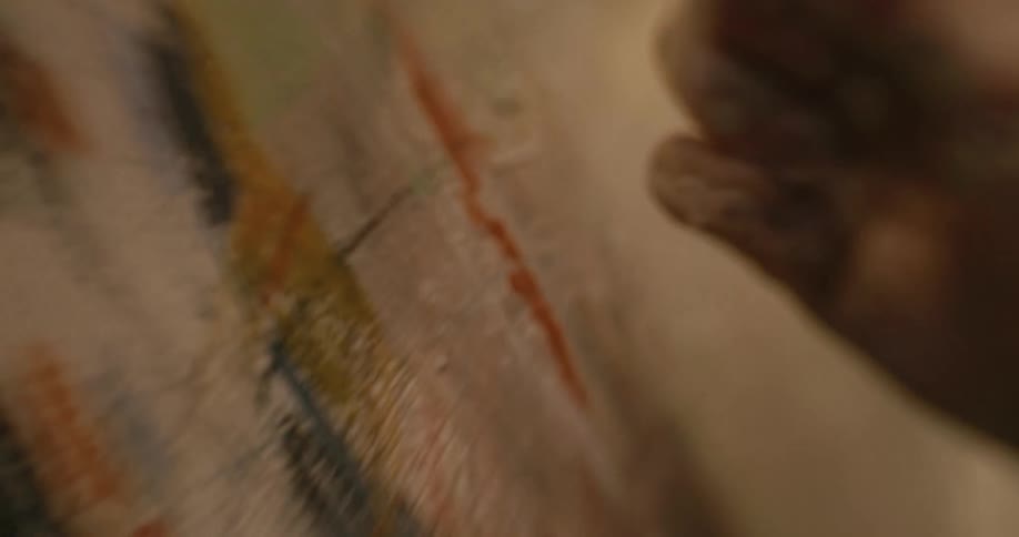 A female hand using crayons to paint on canvas