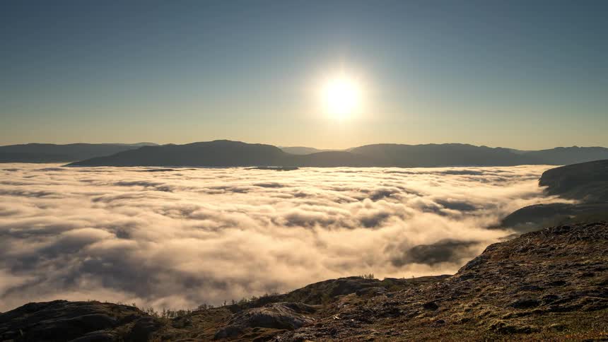 The clouds flow over the mountain tops
