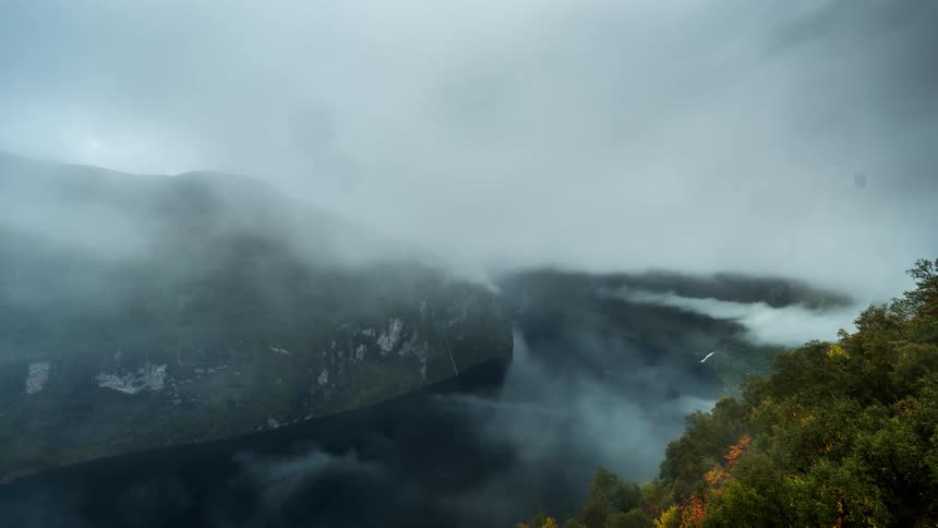 The clouds flow over the river and mountains