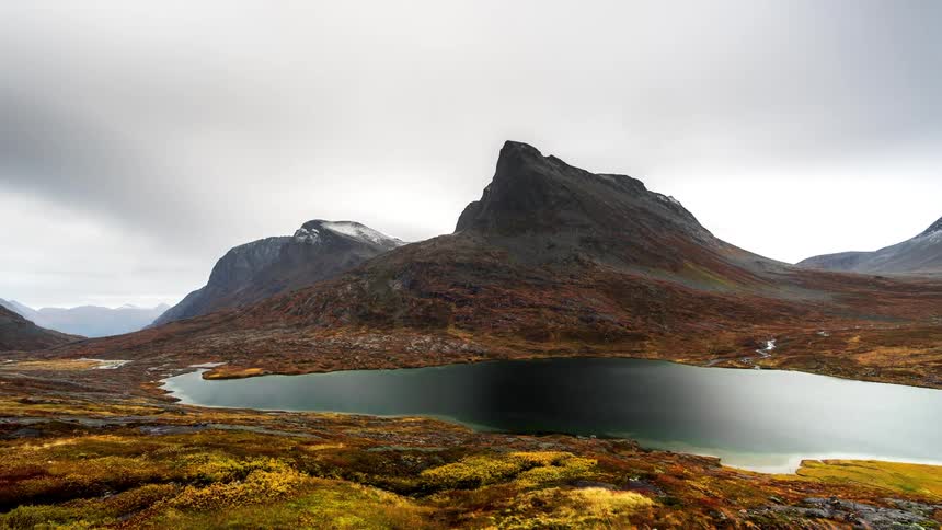 Rocky with lake and clouds passing by in timelapse
