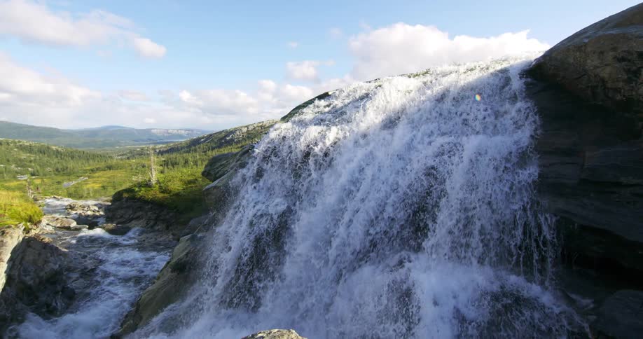 A water fall pours off the cliff