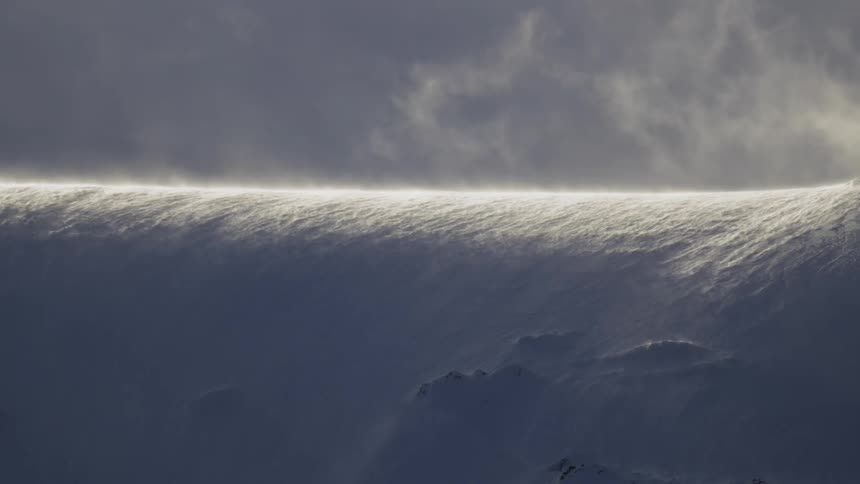 Natural landscape of a mountain covered by snow in snow flying with the force of the wind