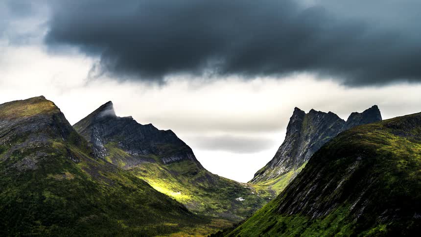 The clouds flow over the mountain range