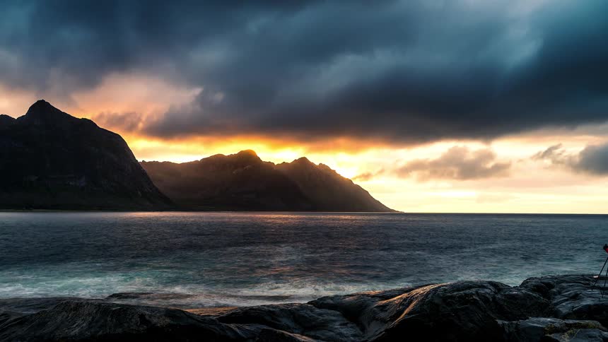 Dark clouds move over the coast as waves roll into shore