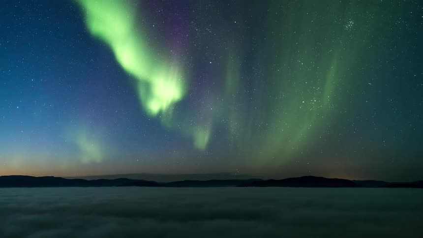 The aurora borealis lights up the starry sky at dusk