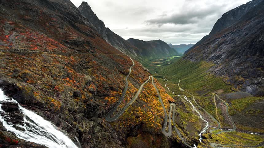 A time lapse of a mountain range with cars driving on streets and flowing streams
