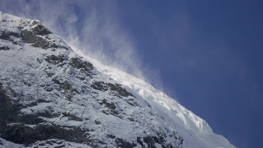 Wind lifting snow off a mountains side