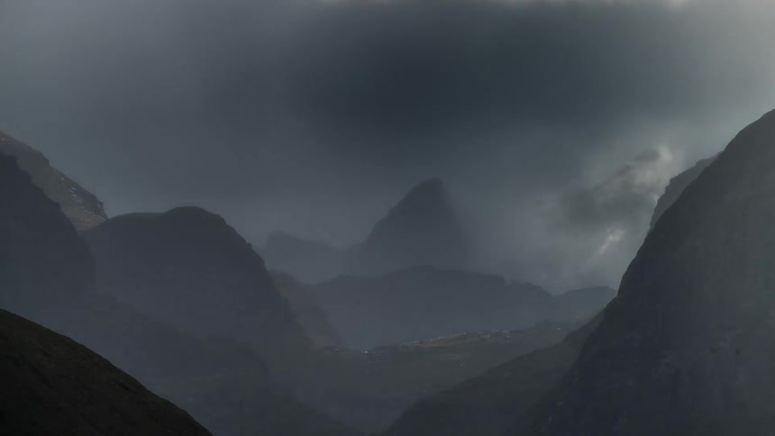 The mountains are covered in black clouds during the day