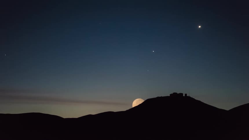 Silhouettes of mountains during starry sky with full moon