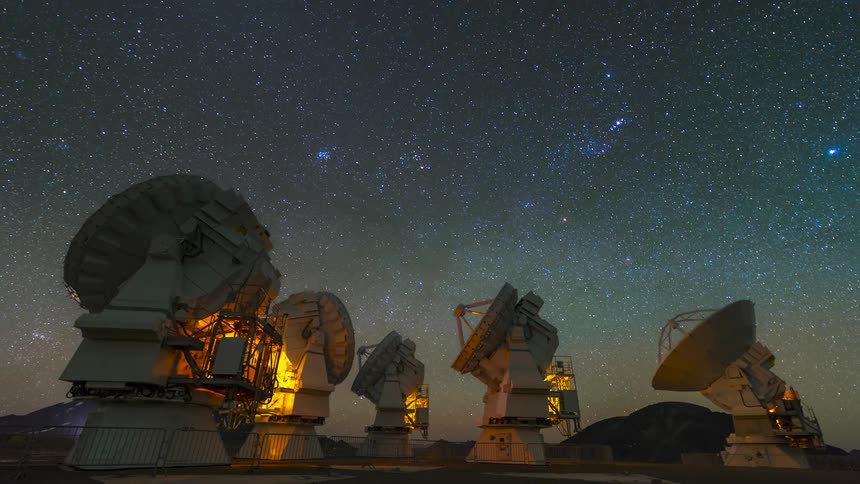 Scientific antennas pointed at the sky with stars in timelapse