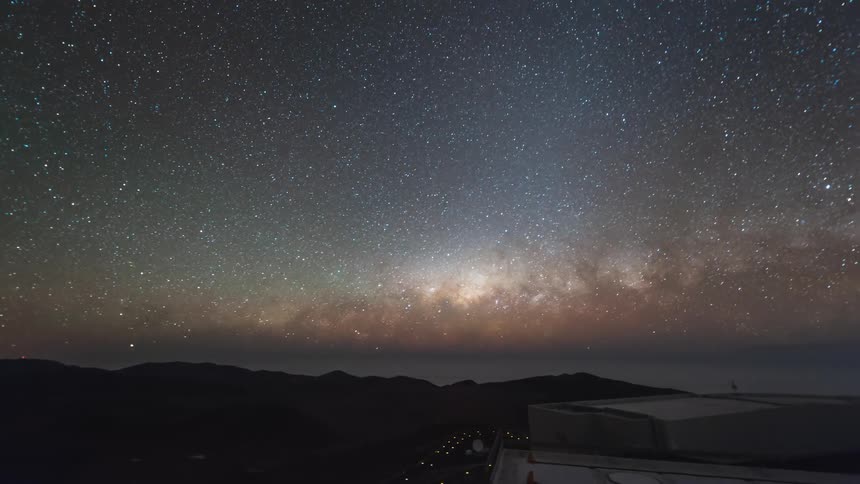 A starry sky is spinning and below there is an observatory