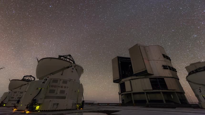 Research equipment with antenna platforms pointed at the sky with nebula at night