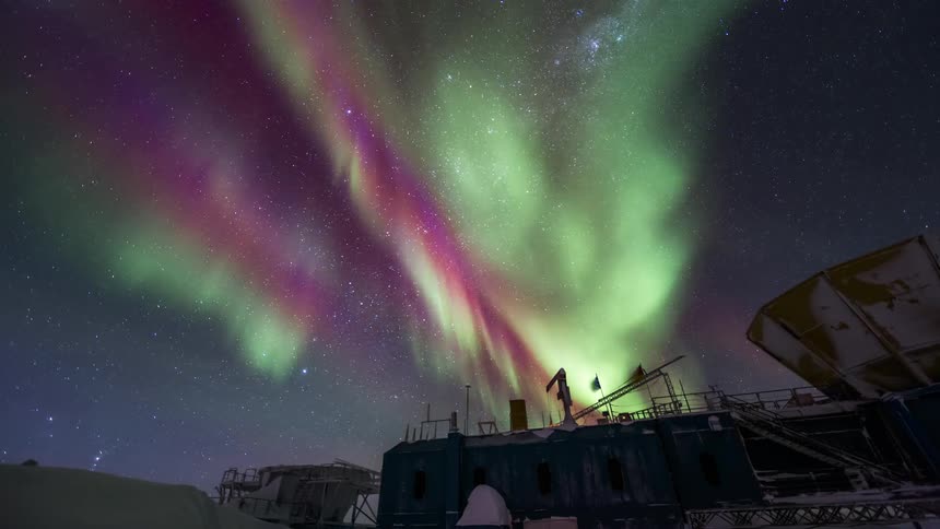 The aurora flashes above the building