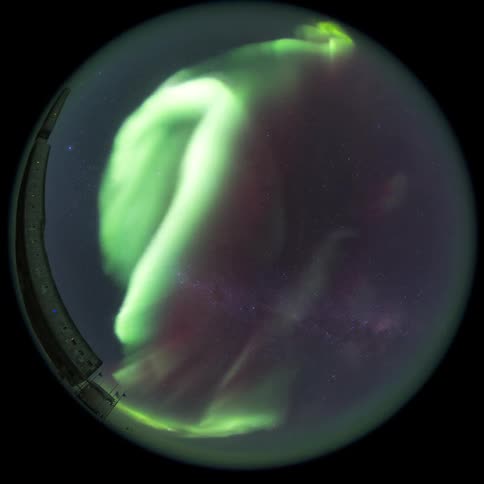 A bright green colored Aurora Australis in the sky seen by a fisheye camera