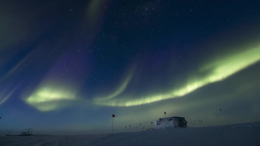 The aurora moves over the building