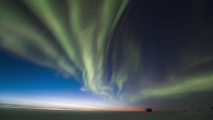 An aurora fills the sky at dawn or dusk