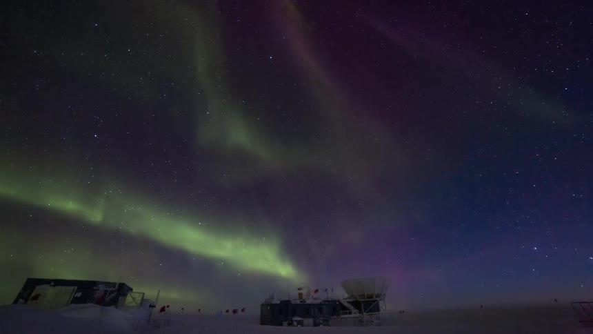 Research stations in antarctica with the Aurora Australis lighting up the starry sky