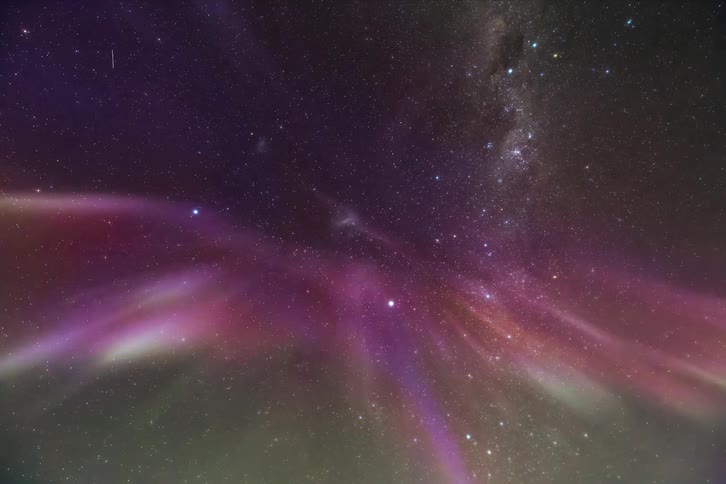 A starry sky in a night with bright pink and green lights