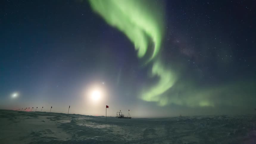 An aurora lights up the sky as the sun rises