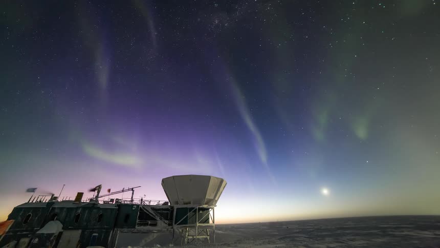 Scientific center amid snow with view of the night sky with Aurora Australis