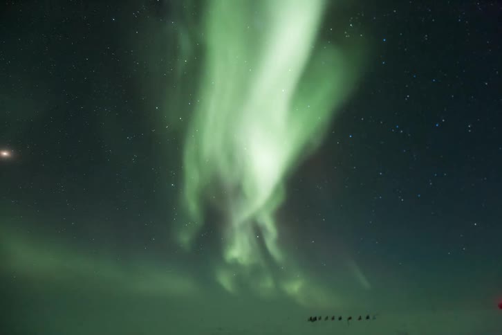 An aurora twists in the night sky